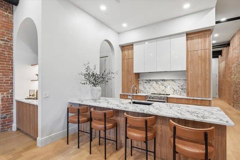 Model Unit 209 kitchen with walnut cabinetry and marble island