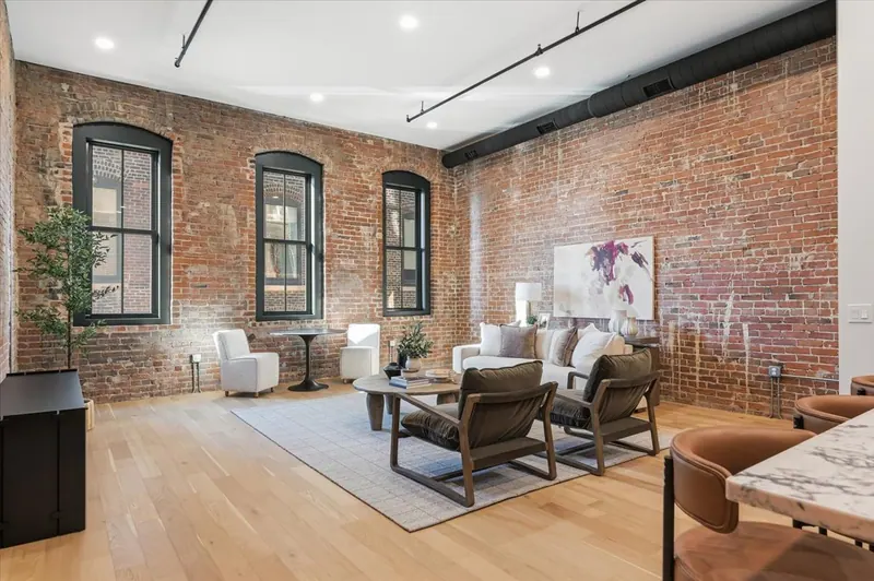 Model Unit 209 living room with exposed brick and arched windows